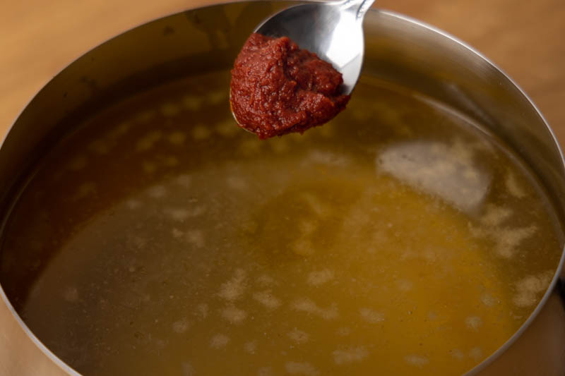 Adding tomato paste to chicken broth