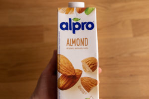 Almond milk carton in hand
