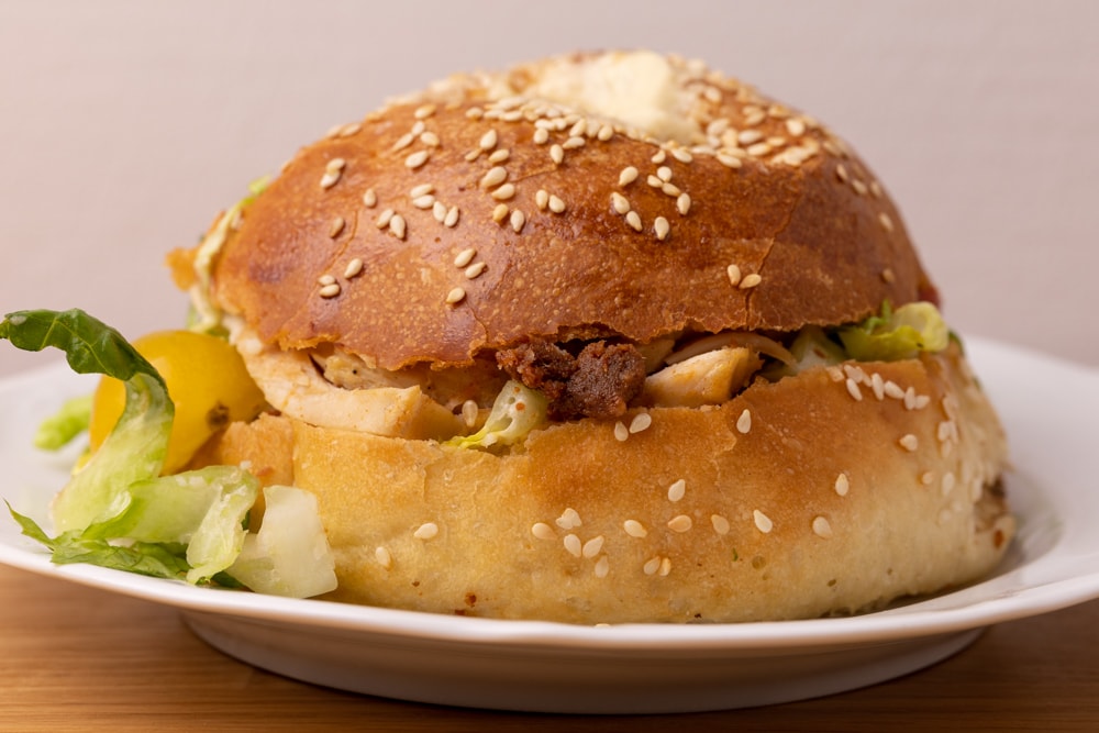 Bagel sandwich with lettuce, chicken, and sauce