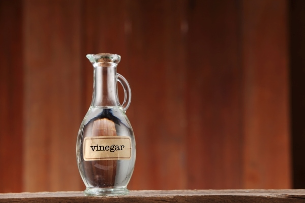 Bottle of white wine vinegar on a wooden surface