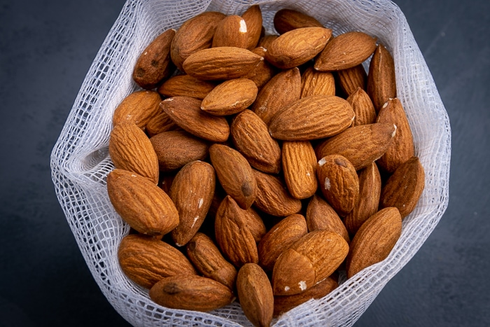 Bunch of unpeeled almonds in a mesh bag