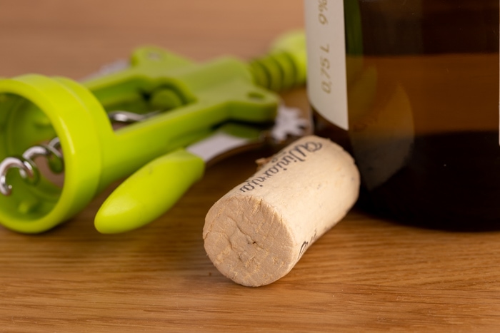 Cork and corkscrew next to wine bottle