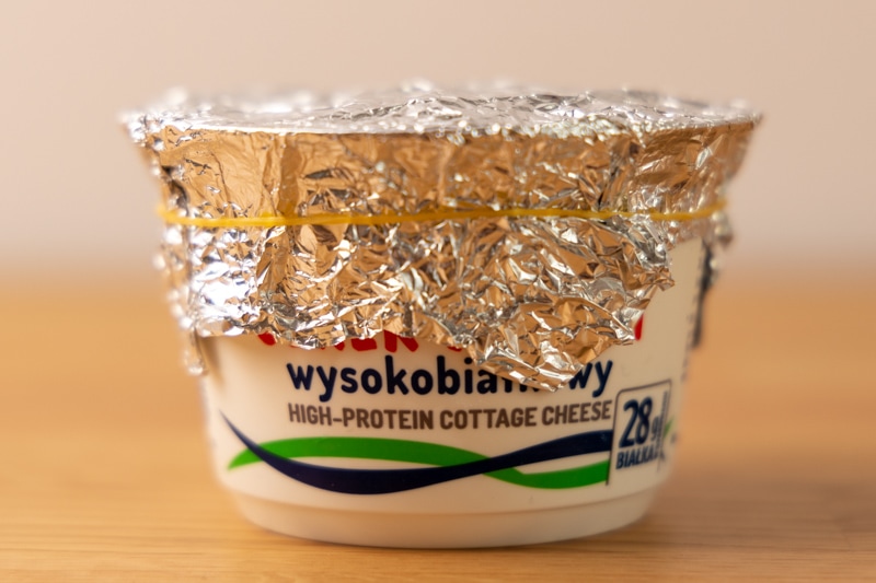 Cottage cheese wrapped with aluminum foil and a rubber band