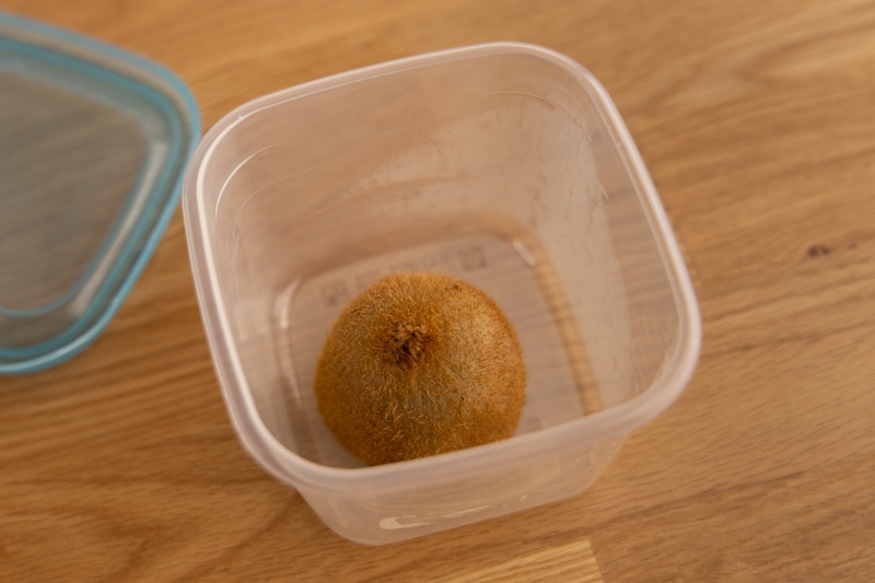 Cut kiwi in a container - cut side down