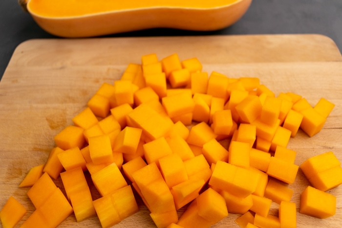 Cutting butternut squash on a wooden cutting board