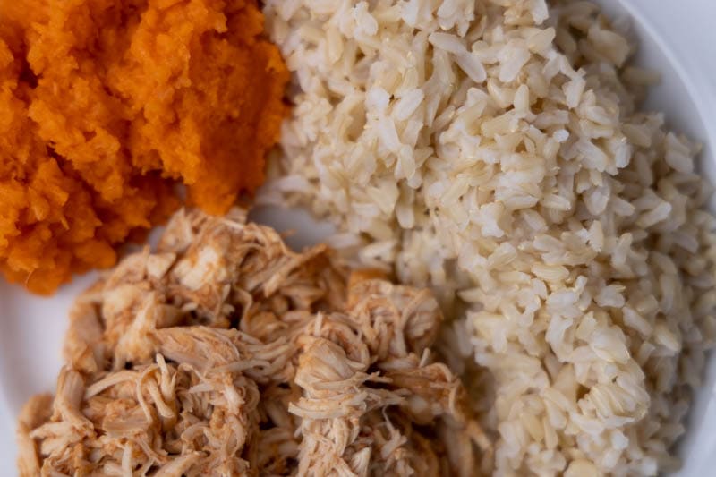 Dinner with BBQ chicken, rice, and grated carrots