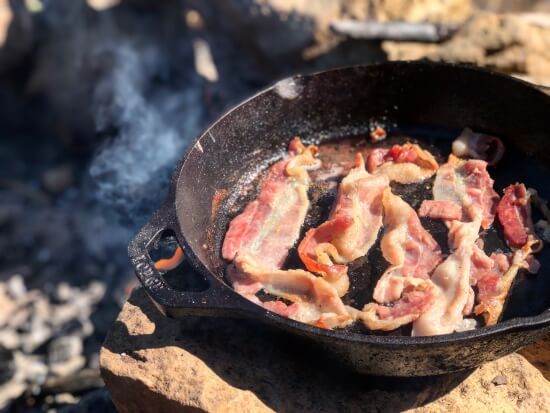 Frying bacon in a frying pan