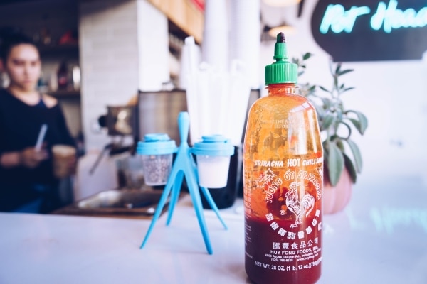 Half-full bottle of Sriracha sauce