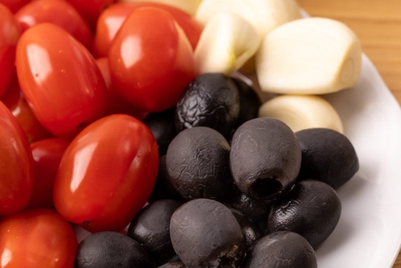 Olives tomatoes and garlic on a plate