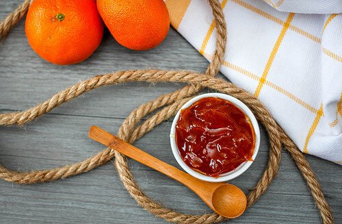 Orange jam with a wooden spoon