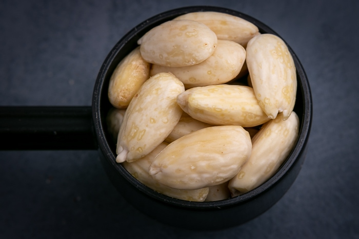 Peeled almonds in a scoop