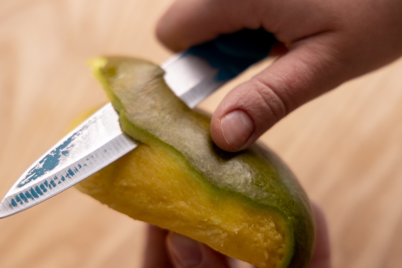 Peeling mango with a knife