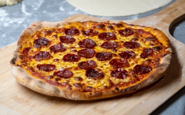 Pepperoni pizza on a wooden tray