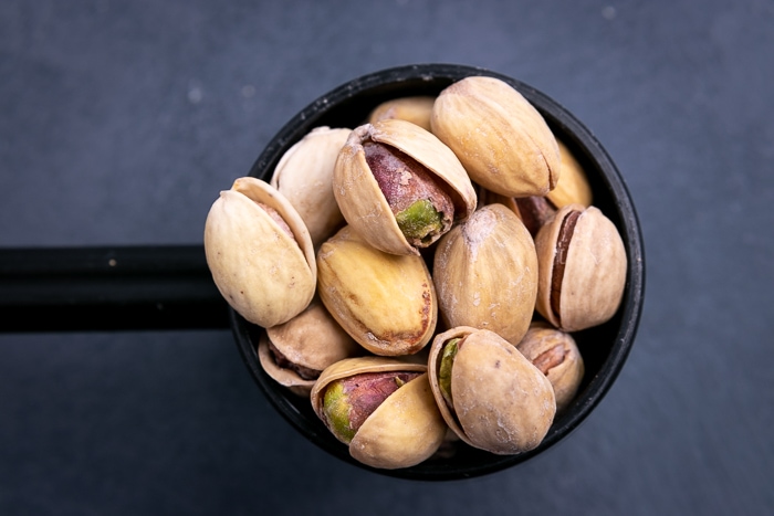 Pistachios in a black scoop