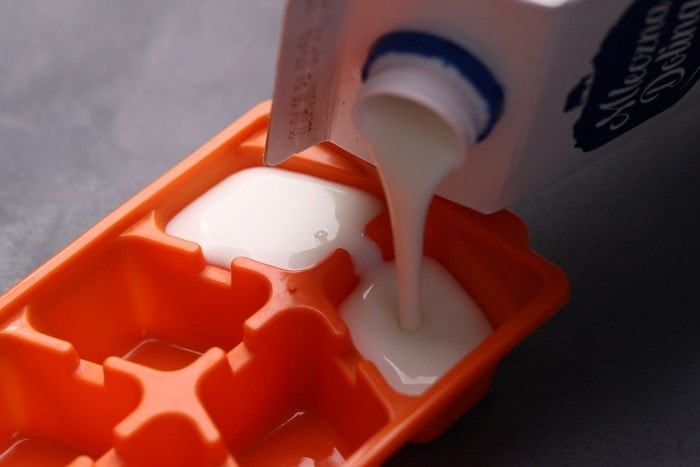 Pouring buttermilk into an ice cube tray