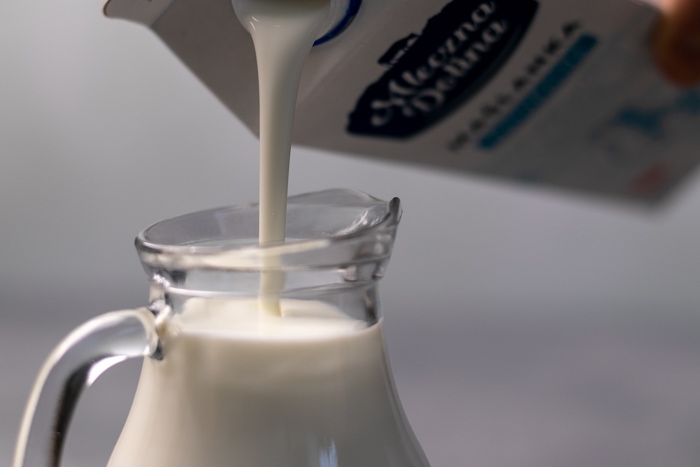 Pouring buttermilk into a glass jug
