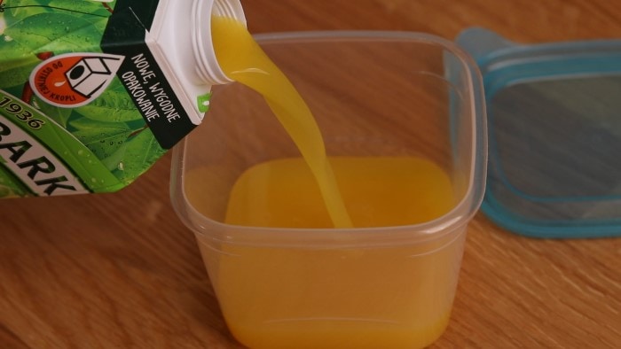 Pouring orange juice in a container