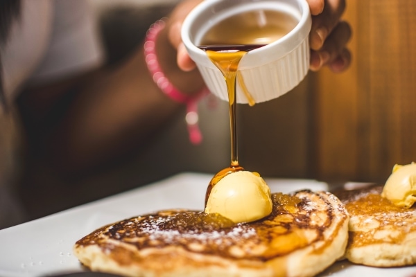 Pouring syrup over pancakes