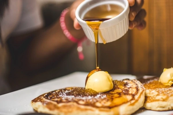 Verser du sirop sur des crêpes