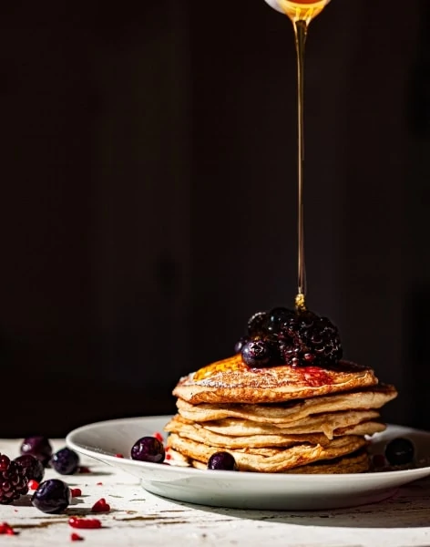 Verser du sirop sur une pile de crêpes