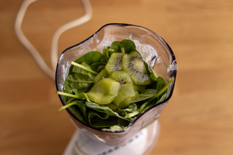 Prepping smoothie with kiwi slices