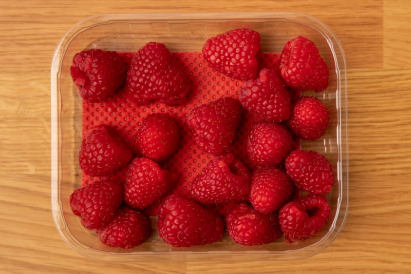 Raspberries in a plastic container