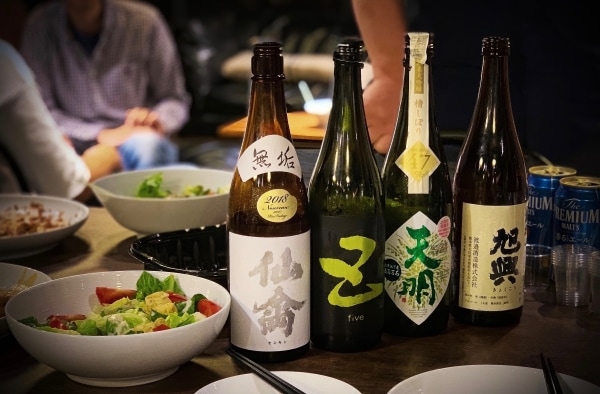 Four sake bottles accompanied by salads