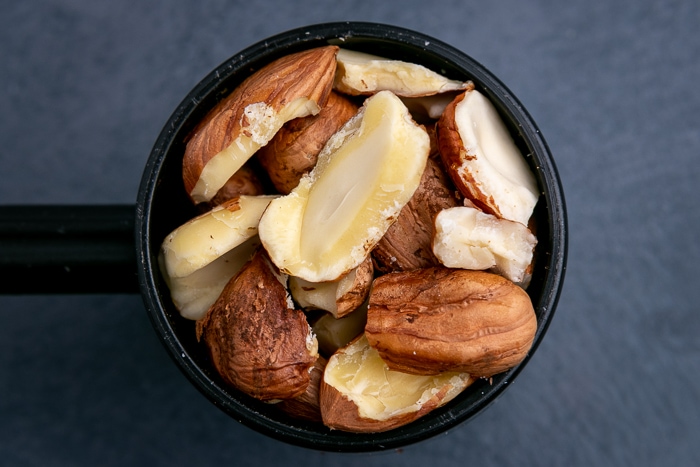 Shelled hazelnuts in a black scoop