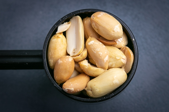 Shelled peanuts in a black scoop