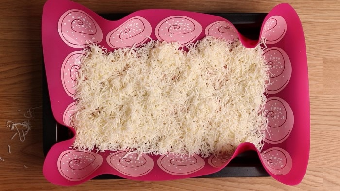 Shredded mozzarella on a cookie tray