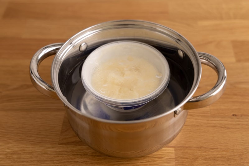 Thawing ricotta setup: frozen ricotta in a pot of lukewarm water