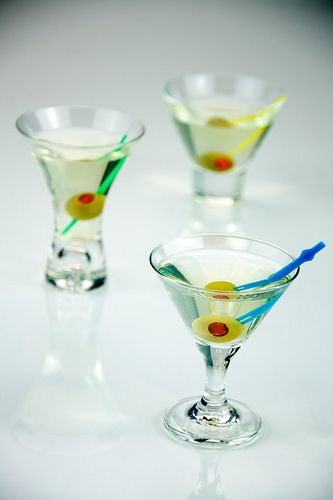 Tre dirty martini in miniatura serviti con una tradizionale guarnizione di olive