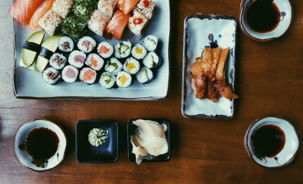 Variety of sushi, and three bowls of soy sauce