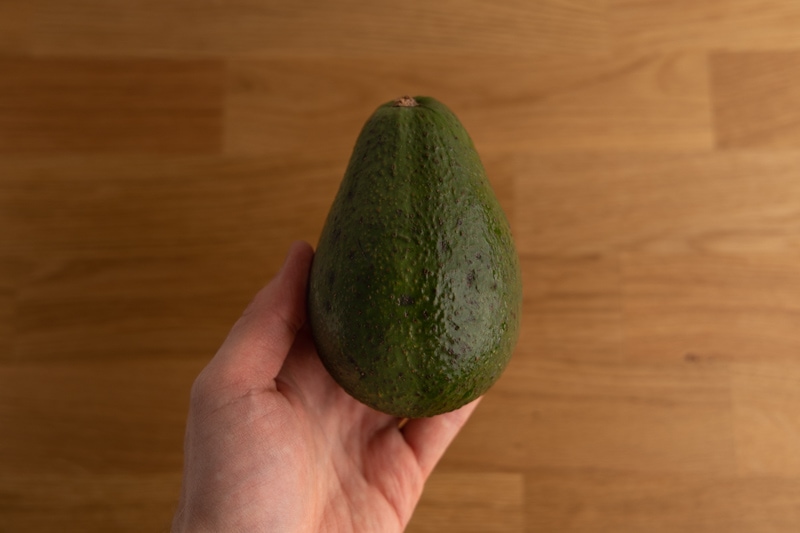 Whole avocado in hand