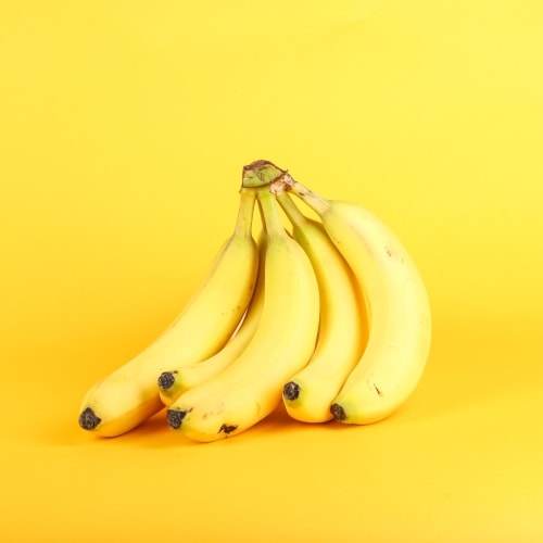 Yellow bananas on yellow background